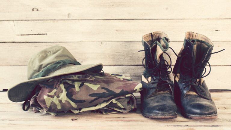 military uniform including boots on a wooden wall