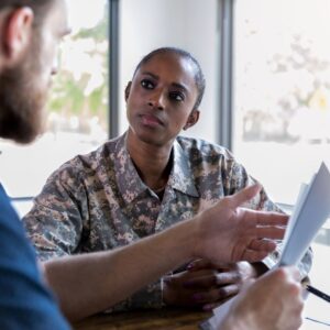 A service member talking to someone with papers