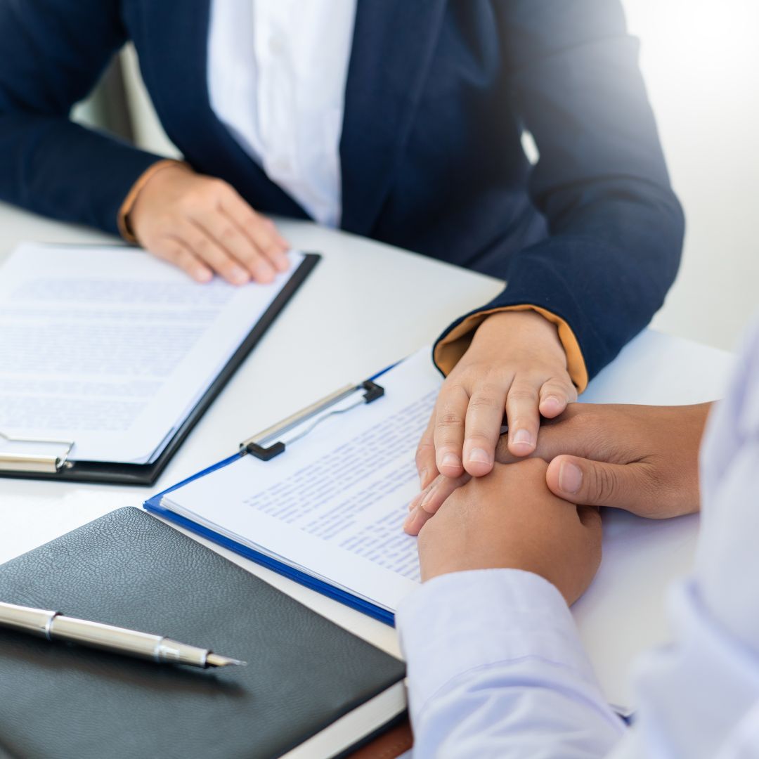 Lawyer with hand over client's hands