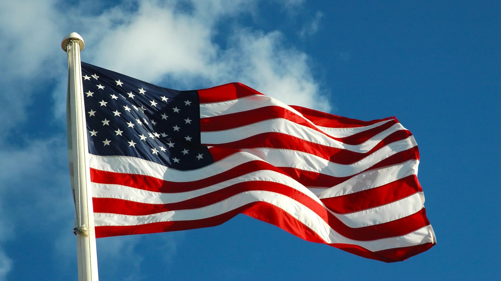 american flag waving in blue sky