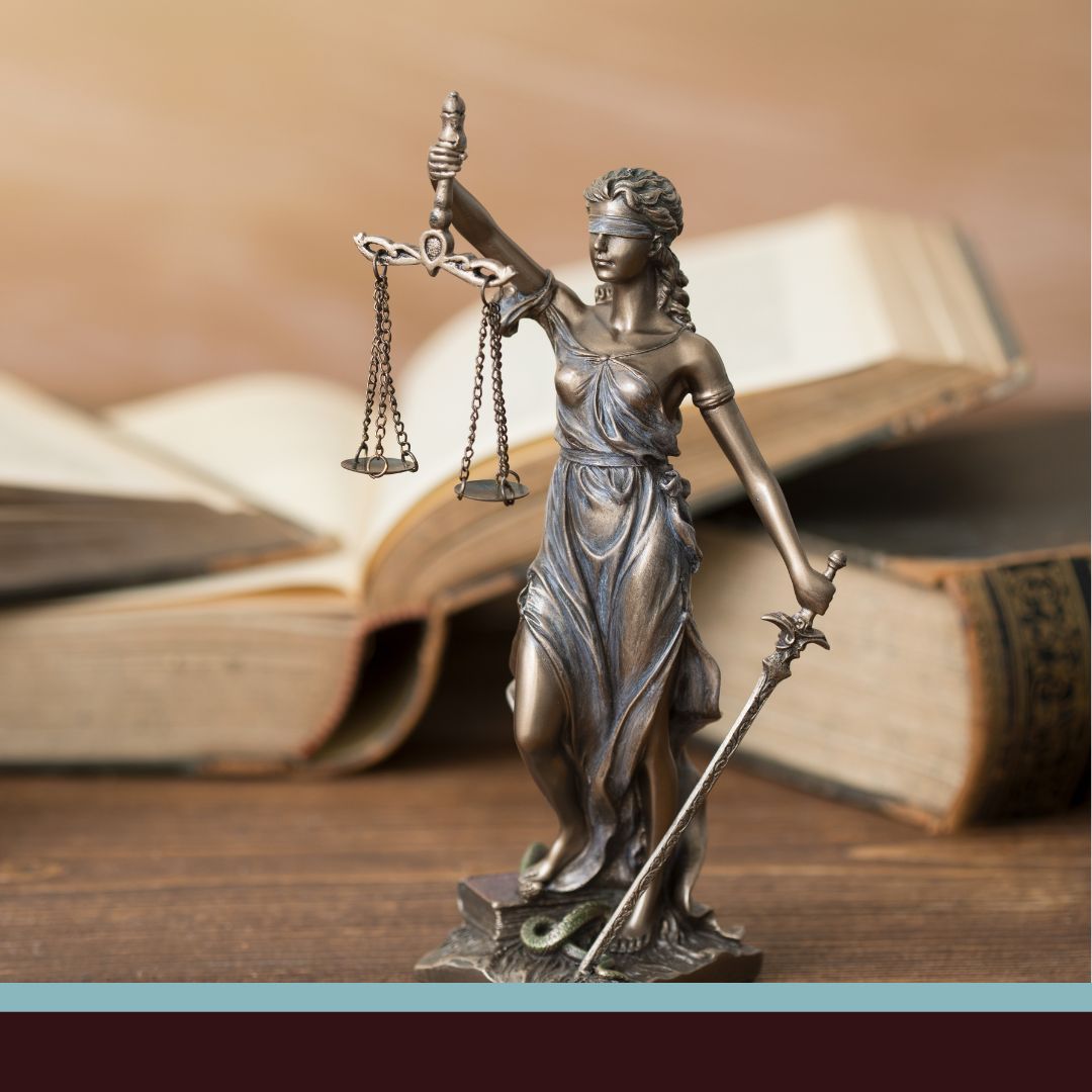 A statue of Themis in front of legal books