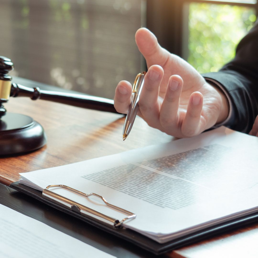 Close-up of hands reviewing official documents on a clean desk. 